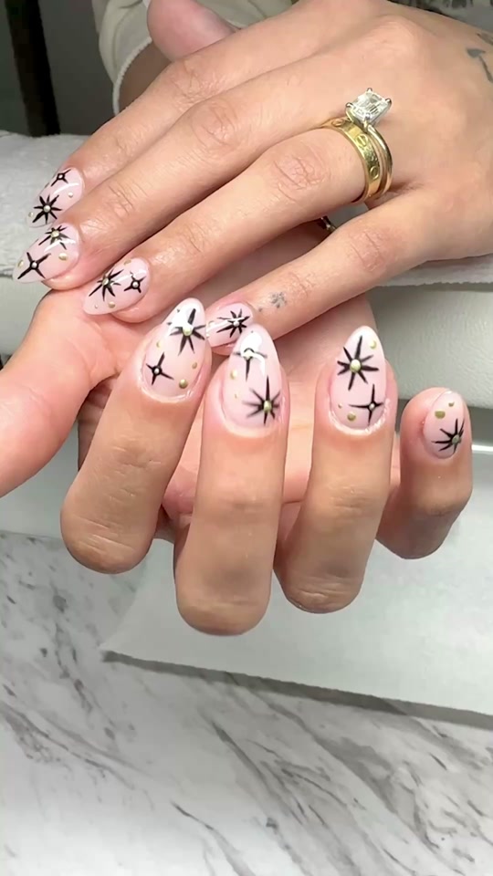 Medium almond Gel-X set in soft pink with hand-painted black starburst art